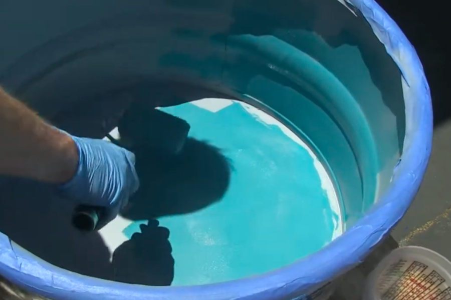 Applying Pond Armor non-toxic epoxy to the interior of a galvanized metal stock tank pool.
