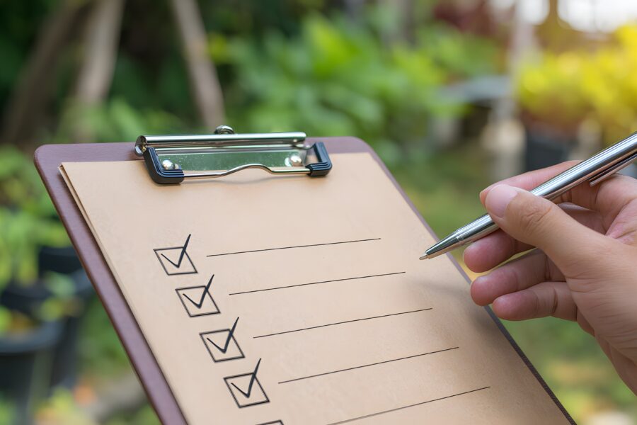 A collection of essential tools for concrete pond repair including an angle grinder, scrub brushes, and Pond Shield epoxy